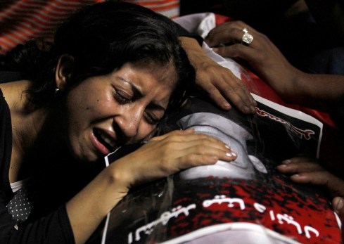 WOMAN MOURNS ON COFFIN OF VICTIM KILLED DURING PROTEST IN CAIRO